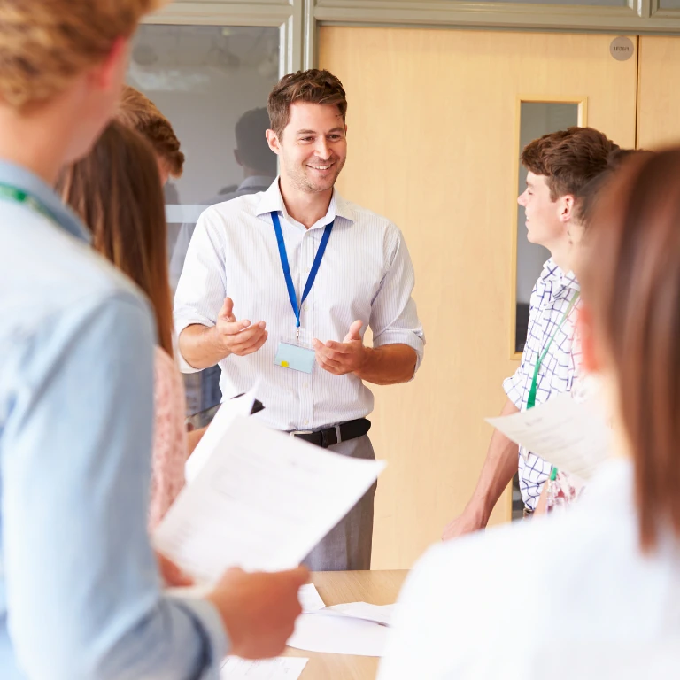 Young male teacher leads a staff meeting with other teachers