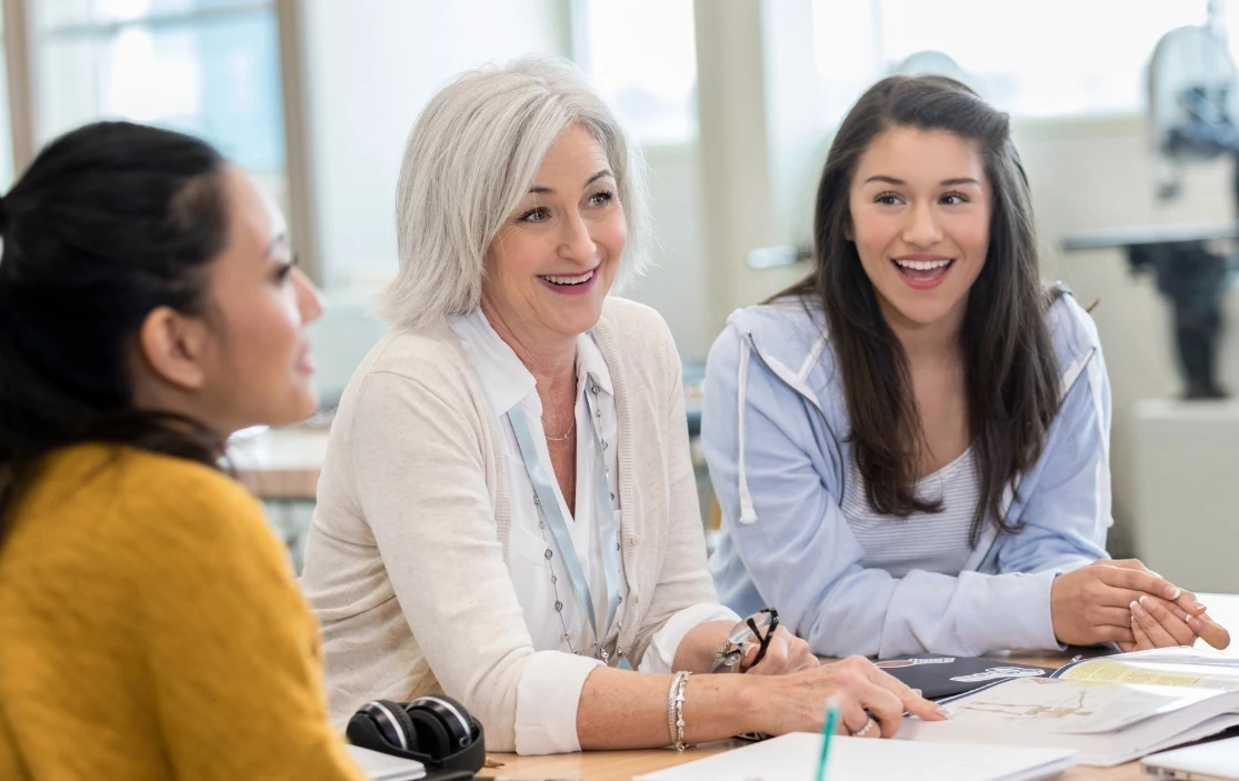 Three smiling women during a school meeting