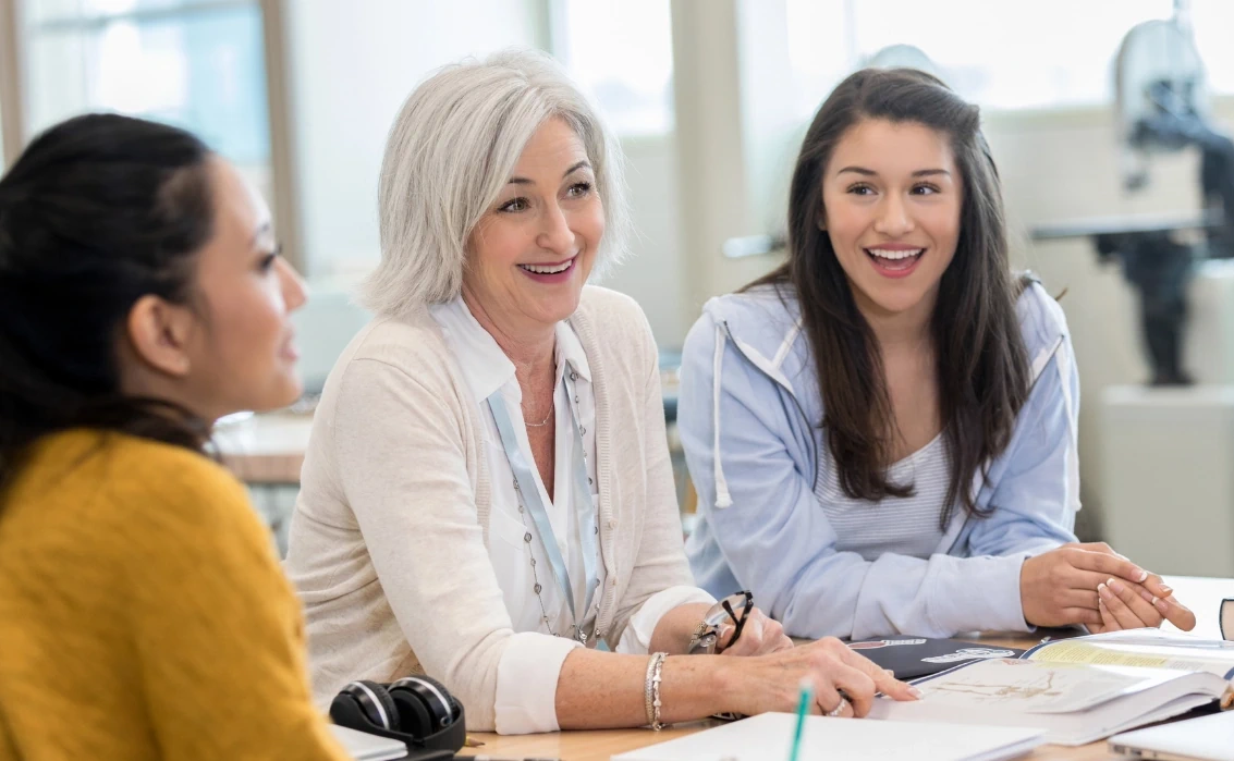 Three female teachers laughing in a meeting